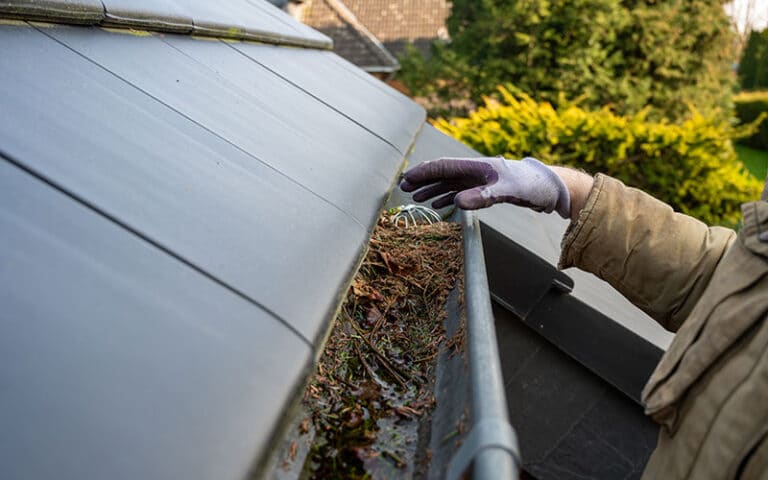 Handyman cleaning a home gutter